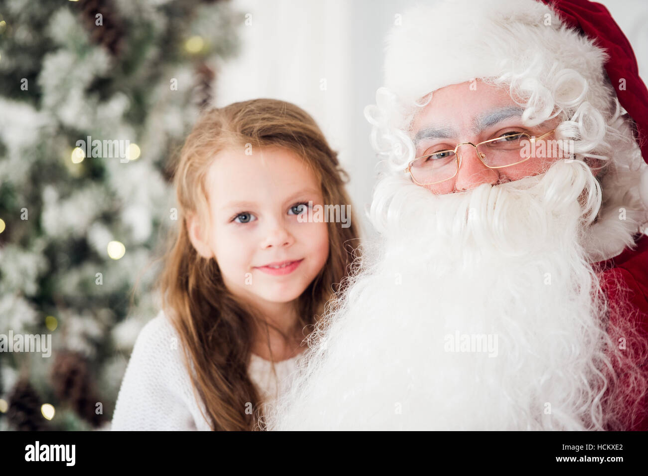 Bambina parlando con un vecchio Babbo Natale Foto Stock