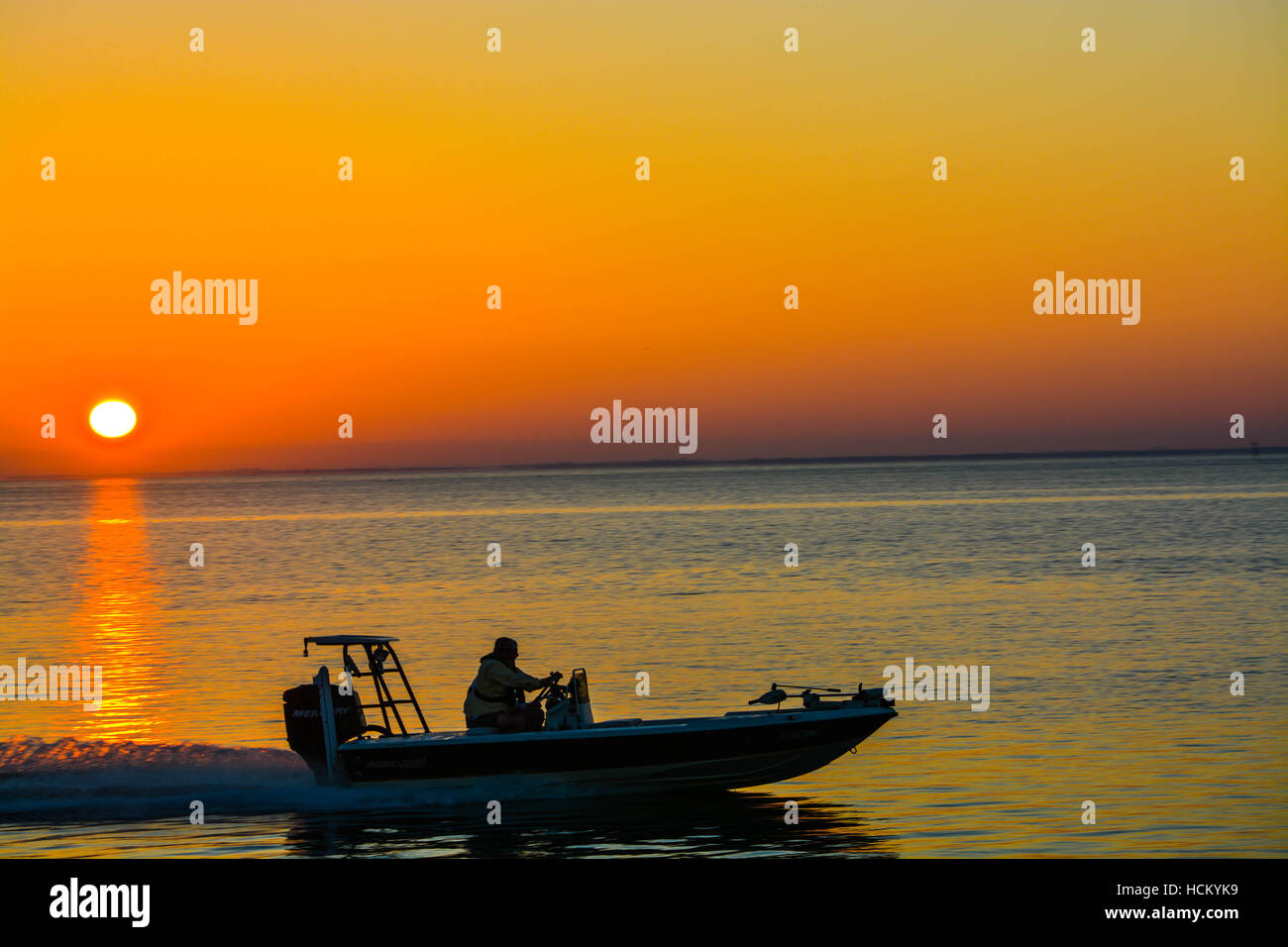 Barca da pesca accelerando da presso sunrise Foto Stock