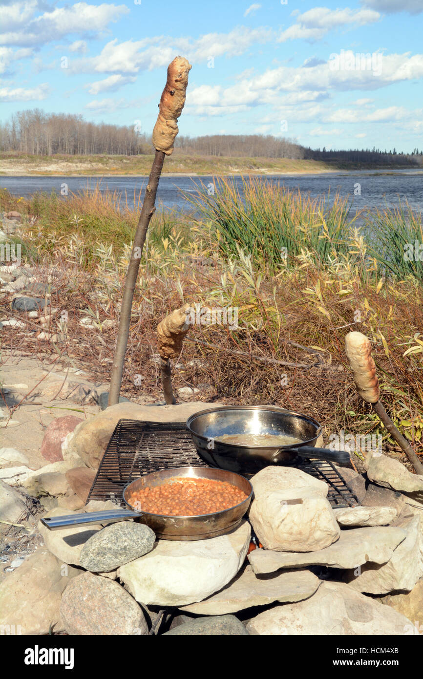 Bannock su un bastone, nativo North American food simile al pane cotti su un falò nel nord Ontario, Canada. Foto Stock