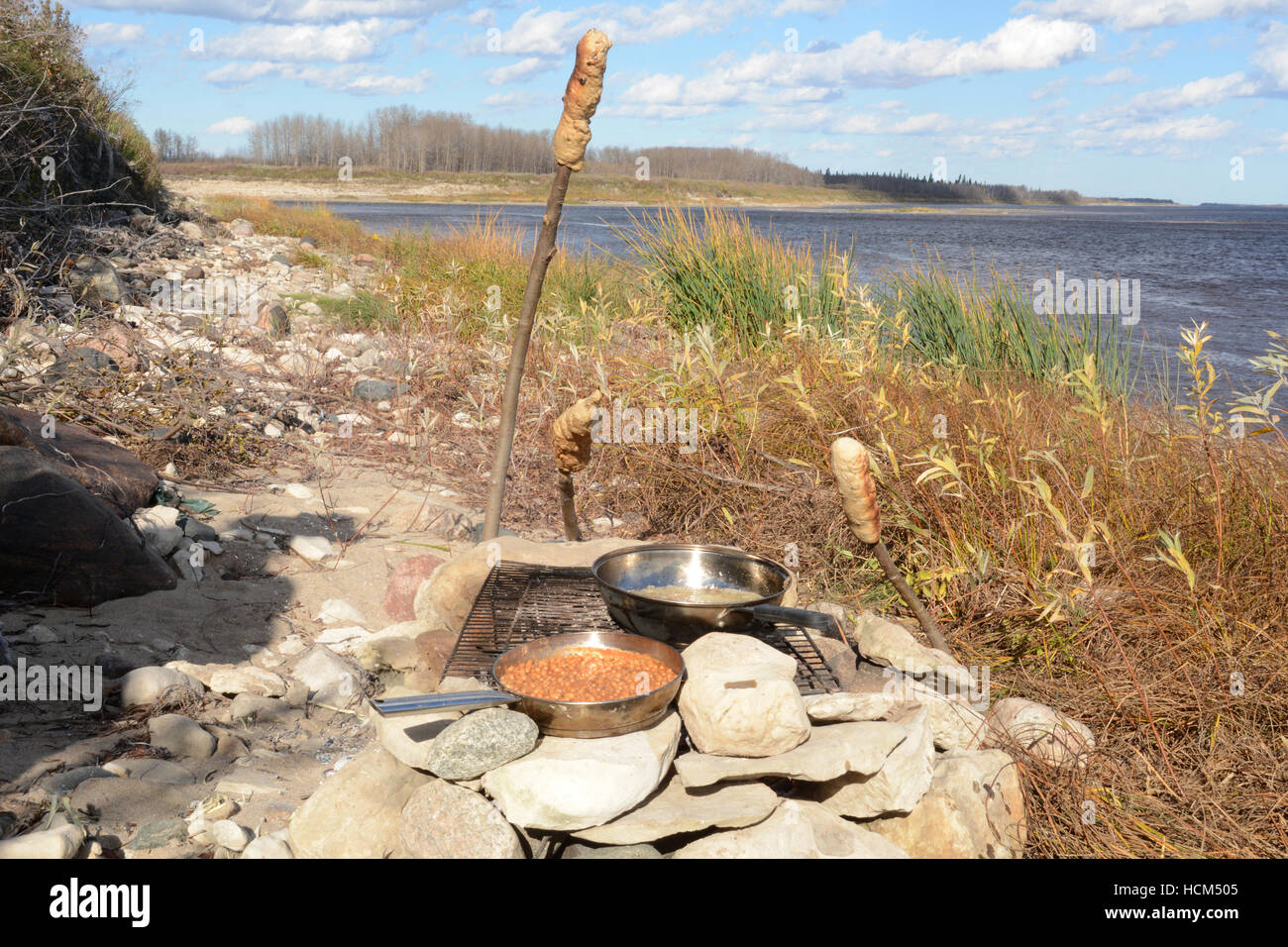 Bannock su un bastone, nativo North American food simile al pane cotti su un falò nel nord Ontario, Canada. Foto Stock