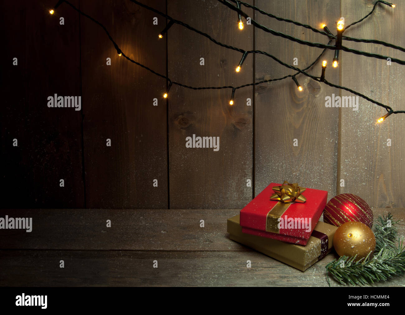 Regali di natale e le luci decorative su uno sfondo di legno con uno spazio Foto Stock