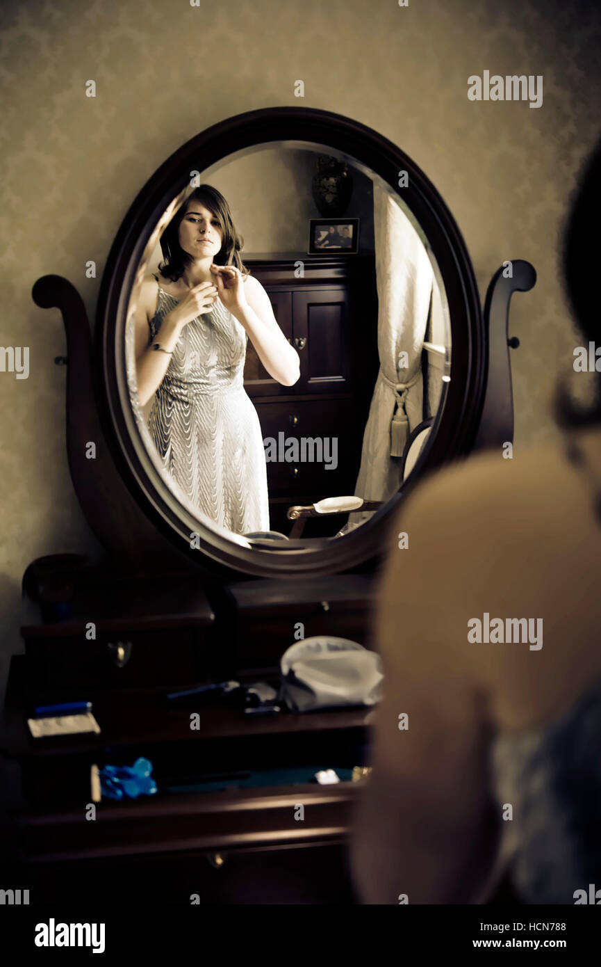 Giovane donna medicazione davanti a uno specchio di cortesia Foto Stock