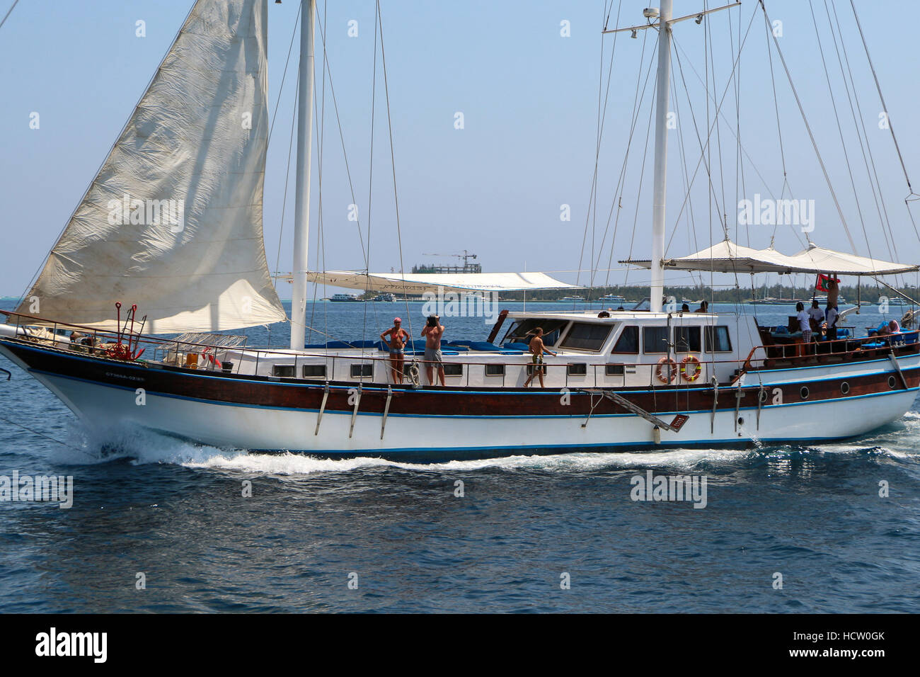 Maschio, Maldive- Febbraio 09, 2013: un vecchio classico barca di legno senza vele in acque aperte. Vista sul bellissimo veliero con le persone felici, da b Foto Stock