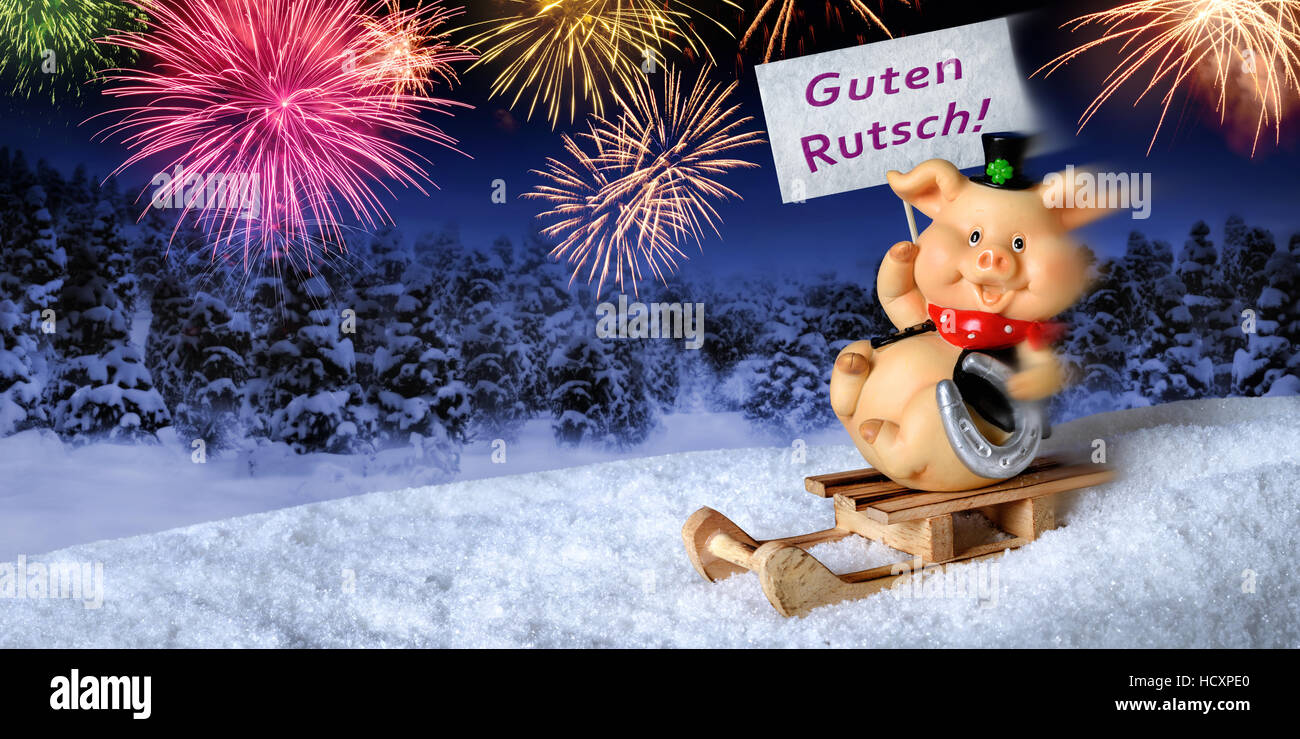 Lucky pig su di una slitta tenendo un cartello che diceva "Guten Rutsch', tedesco per "Felice Anno Nuovo", con fuochi d'artificio nel cielo notturno Foto Stock