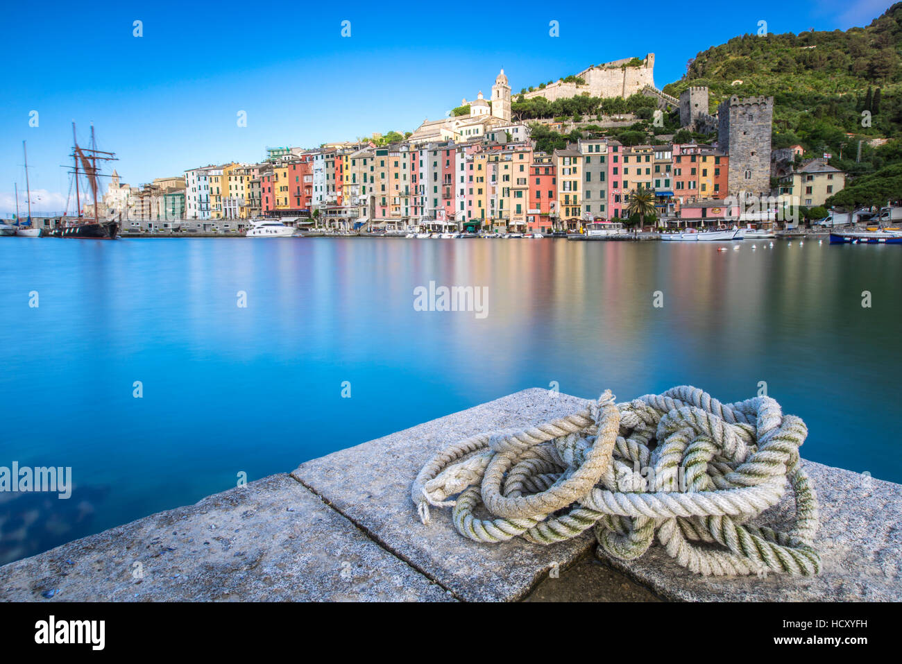 Vista dal molo di mare azzurro che racchiude le tipiche case di Portovenere, UNESCO, provincia della Spezia, Liguria, Italia Foto Stock