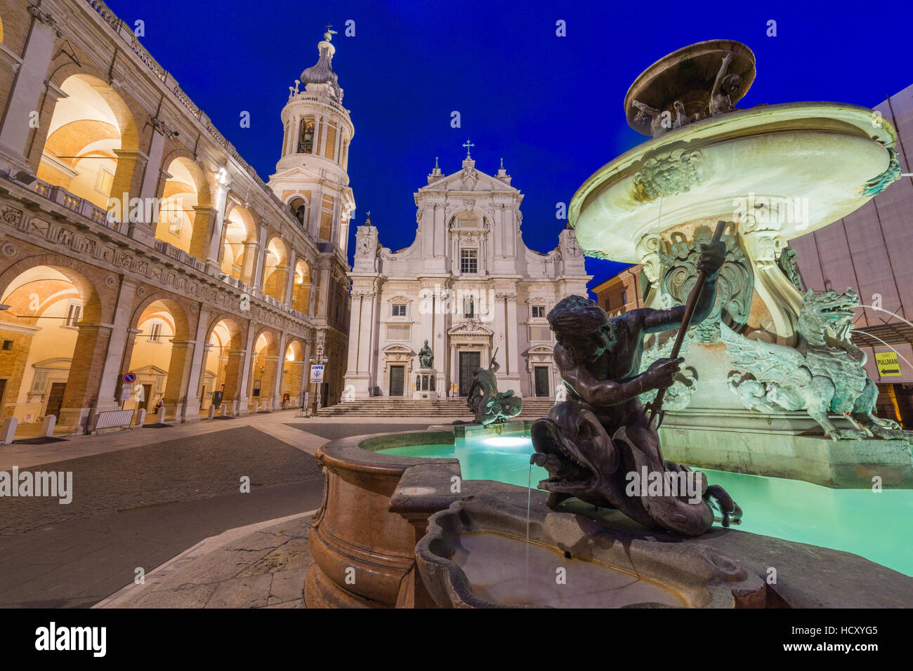 Vista notturna della Basilica della Santa Casa e una fontana decorata con statue, Loreto, in provincia di Ancona, Marche, Italia Foto Stock