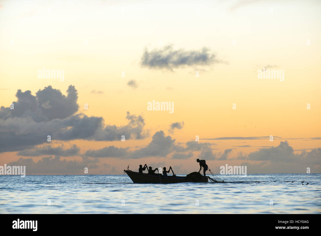 Senna fisherman depongono le loro reti da una barca nella baia di Castara a Tobago al tramonto, Trinidad e Tobago, West Indies, dei Caraibi Foto Stock