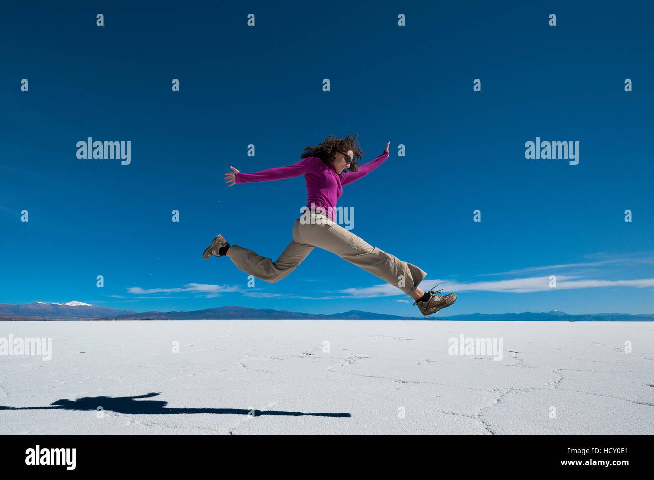 Una ragazza salta in aria a Salinas Grandes (saline) vicino a Purmamarca, Argentina Foto Stock