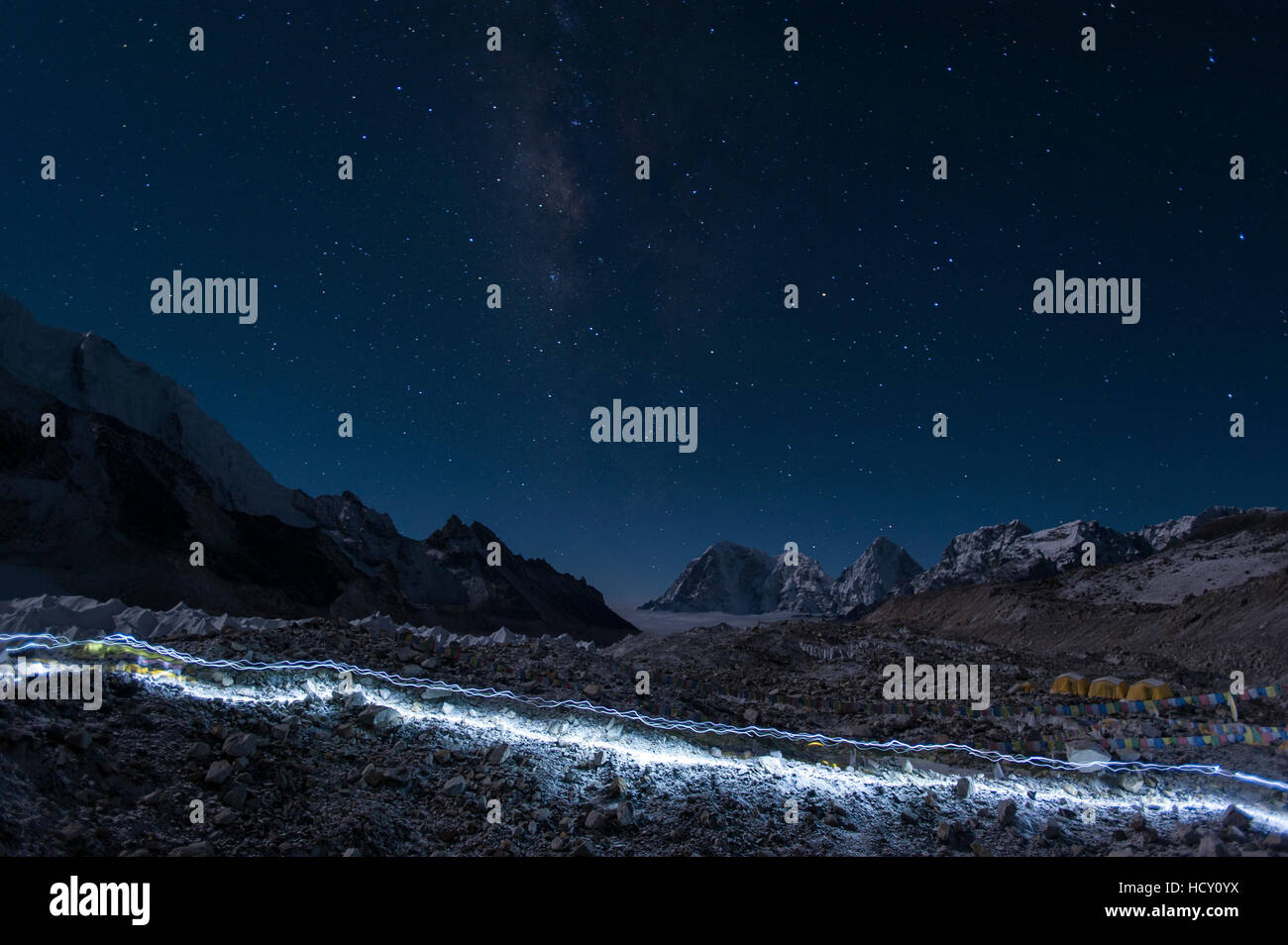 Partenza degli Sherpa, la loro testa-torce di lasciare i sentieri della luce attraverso il ghiacciaio sul loro modo di Everest, Nepal Foto Stock