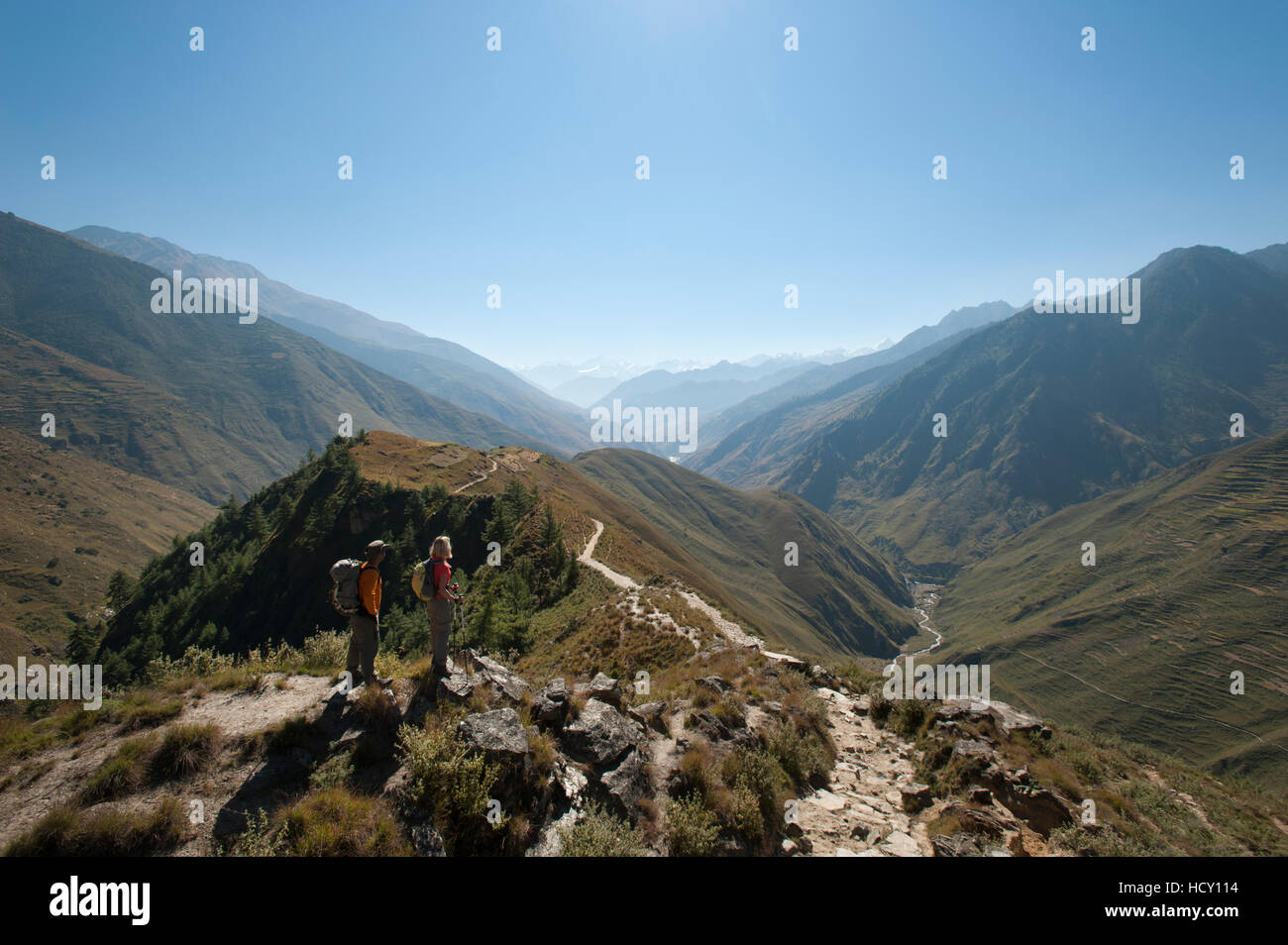Prendendo una pausa dal percorso in corrispondenza di un punto di vista nella valle Juphal, Nepal Foto Stock