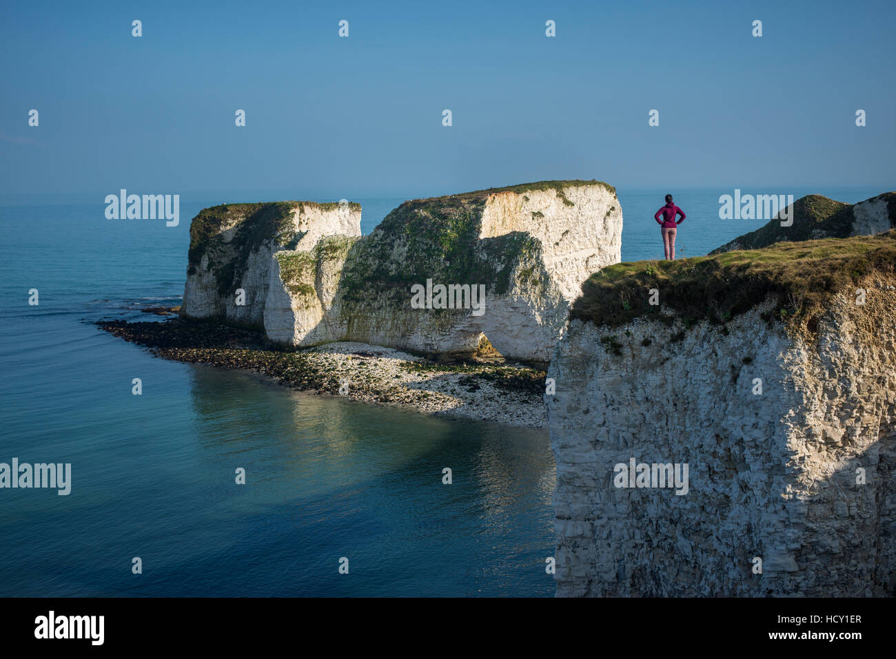 Una donna guarda Old Harry Rocks a Studland Bay, Jurassic Coast, UNESCO, Dorset, Regno Unito Foto Stock