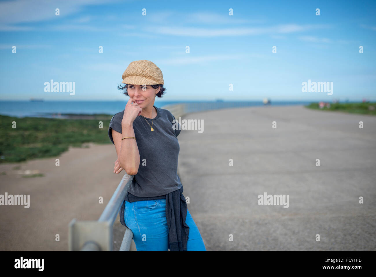 Una donna guarda dal mare muro a Westgate-on-Sea, Kent, Regno Unito Foto Stock