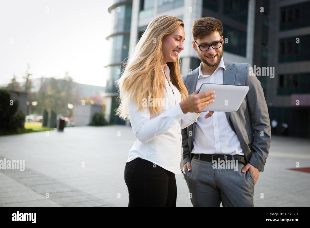 Colleghi di lavoro parlando all'aperto e utilizzo di tablet Foto Stock