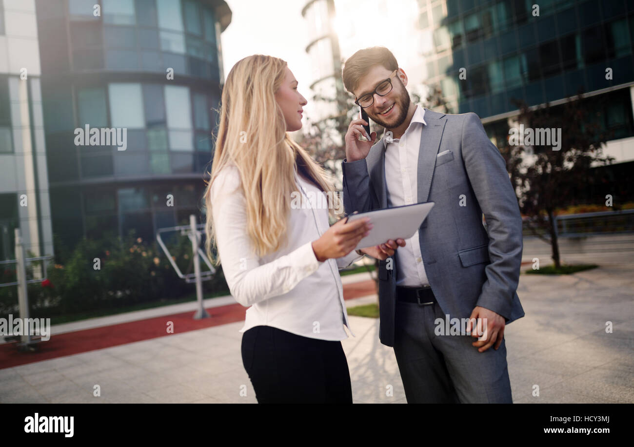 Colleghi di lavoro parlando all'aperto e utilizzo di tablet Foto Stock