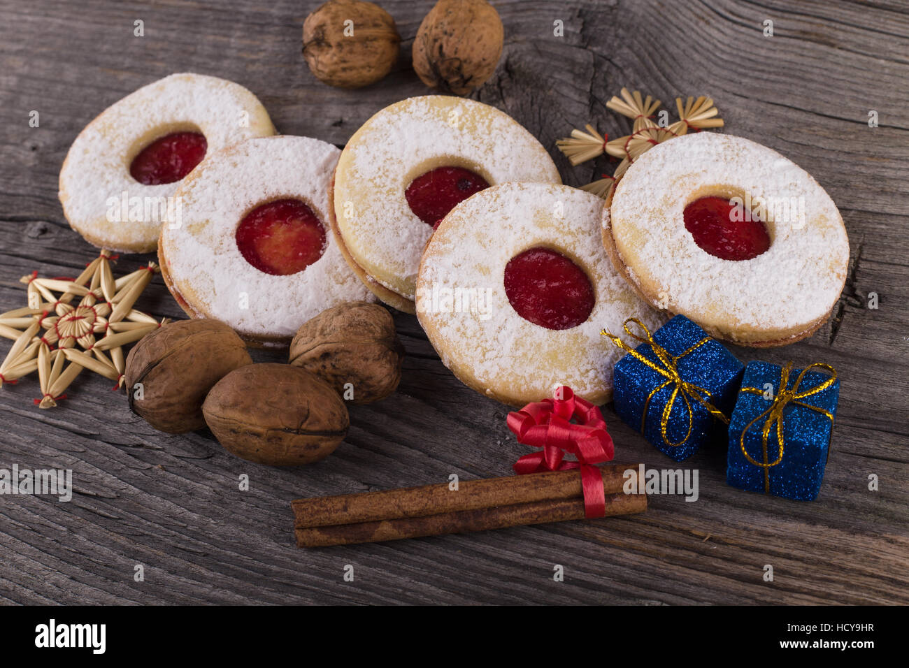In casa i dolci di Natale con lo zucchero in polvere e inceppamento sulla vecchia superficie di legno. Pacchetti di natale e noci. Foto Stock