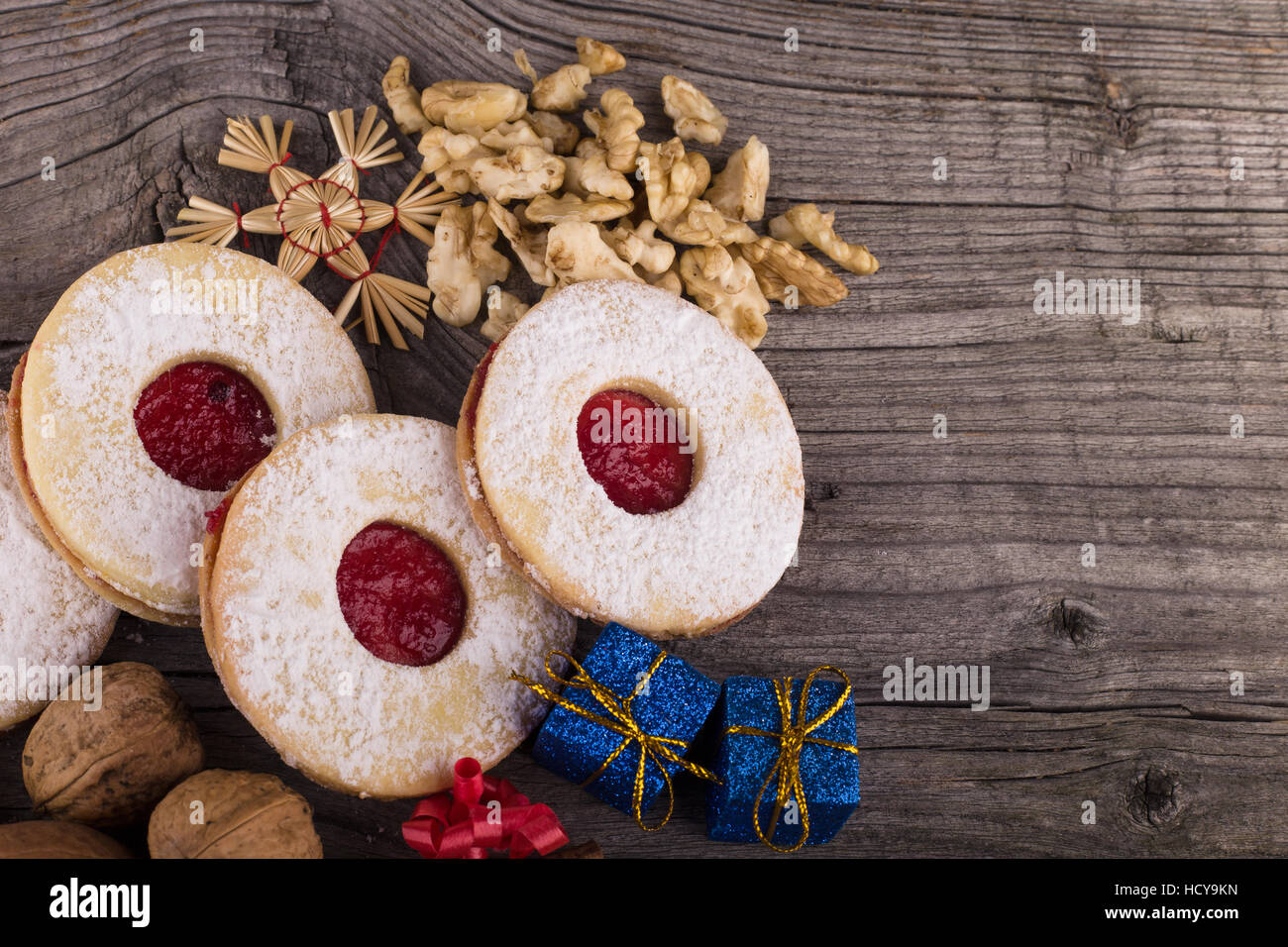 In casa i dolci di Natale con lo zucchero in polvere e inceppamento sulla vecchia superficie di legno. Pacchetti di natale e noci. Foto Stock