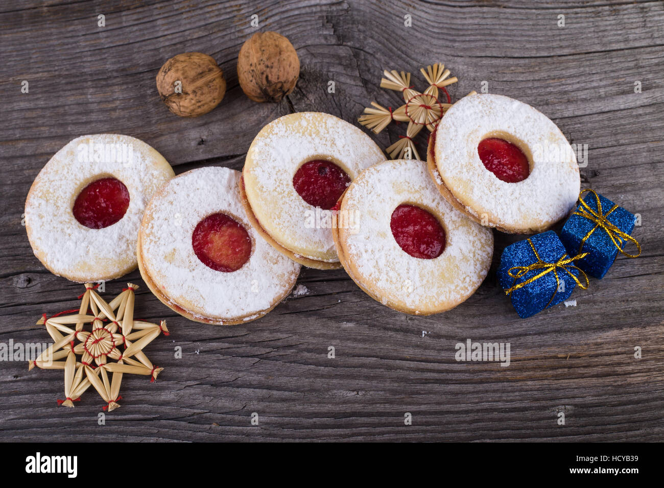 In casa i dolci di Natale con lo zucchero in polvere e inceppamento sulla vecchia superficie di legno. Pacchetti di natale e noci. Foto Stock
