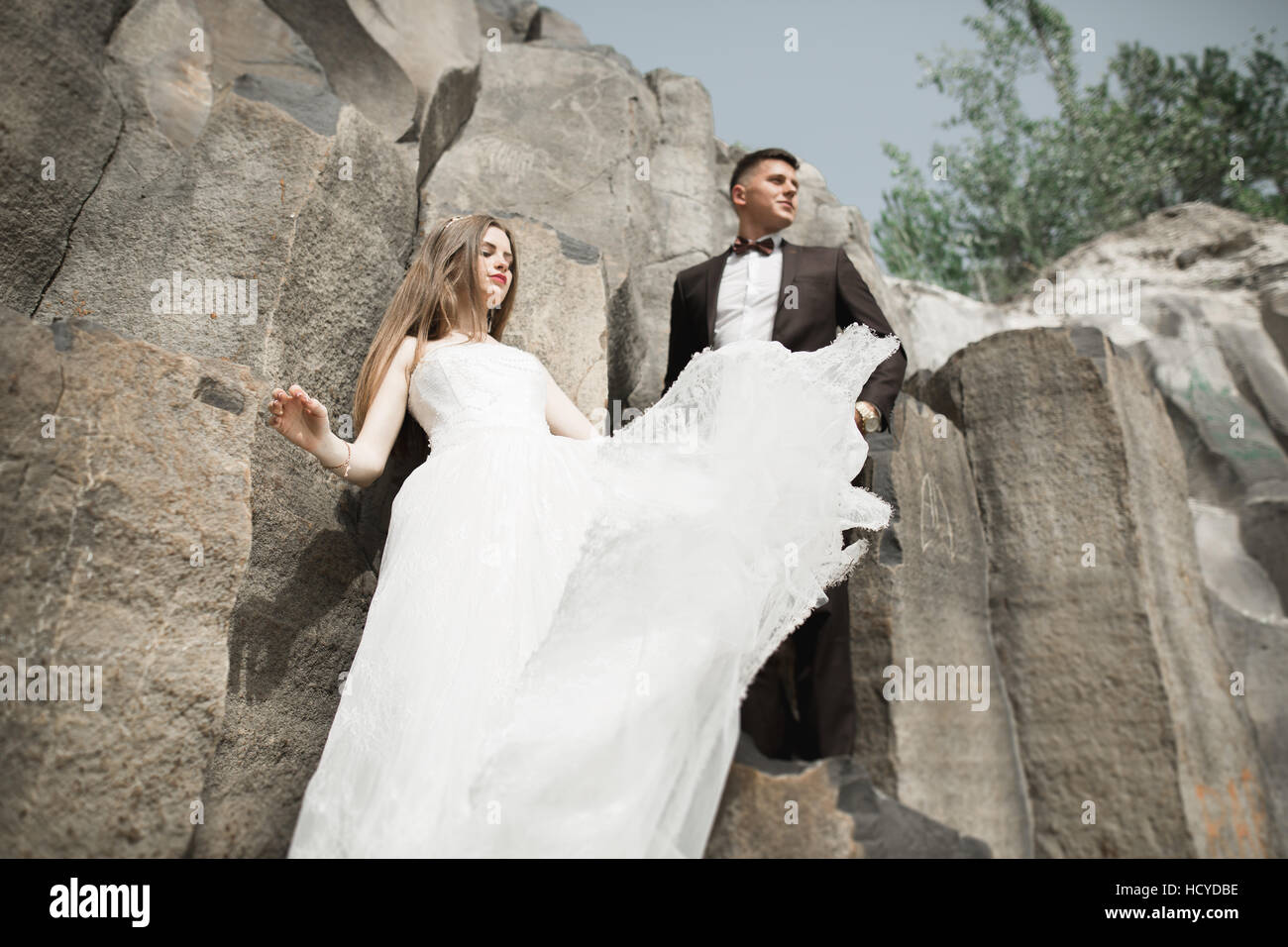 Coppie in viaggio di nozze in amore baciando e abbracciando vicino a rocce sul bellissimo paesaggio Foto Stock