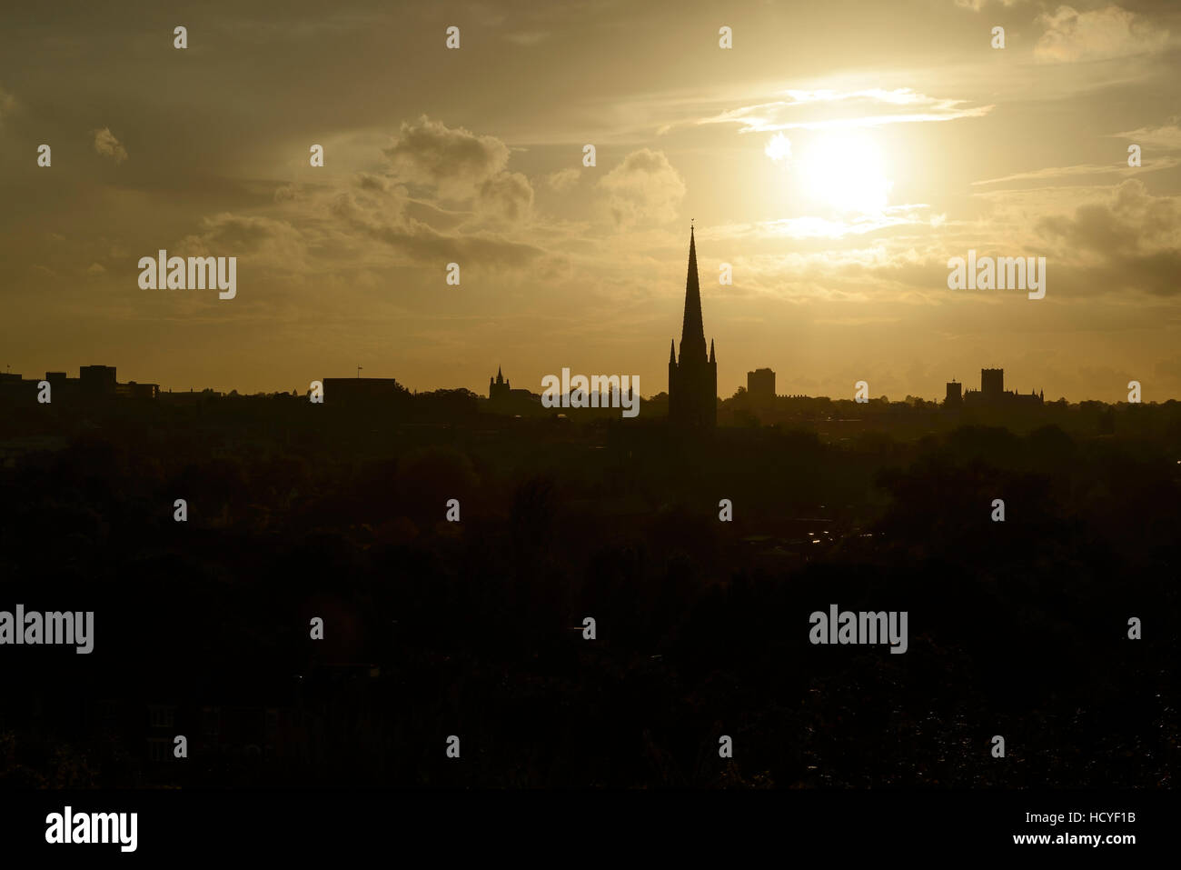 Il sole che tramonta dietro la skyline di Norwich Foto Stock