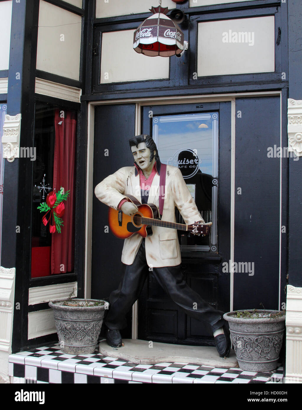 Statua di Elvis strimpella la sua chitarra in Williams Arizona sul percorso 66. Una ghirlanda di Natale adorna la finestra Foto Stock