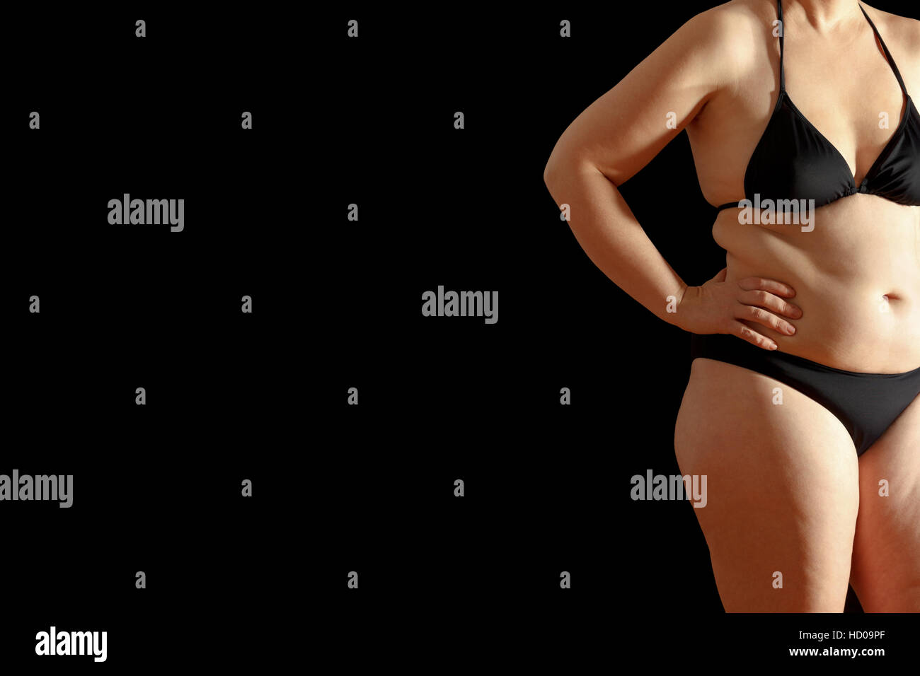 Corpo di donna in bikini con il grasso eccessivo sulla vita e dello stomaco, isolata, sfondo bianco, testo o spazio di copia Foto Stock