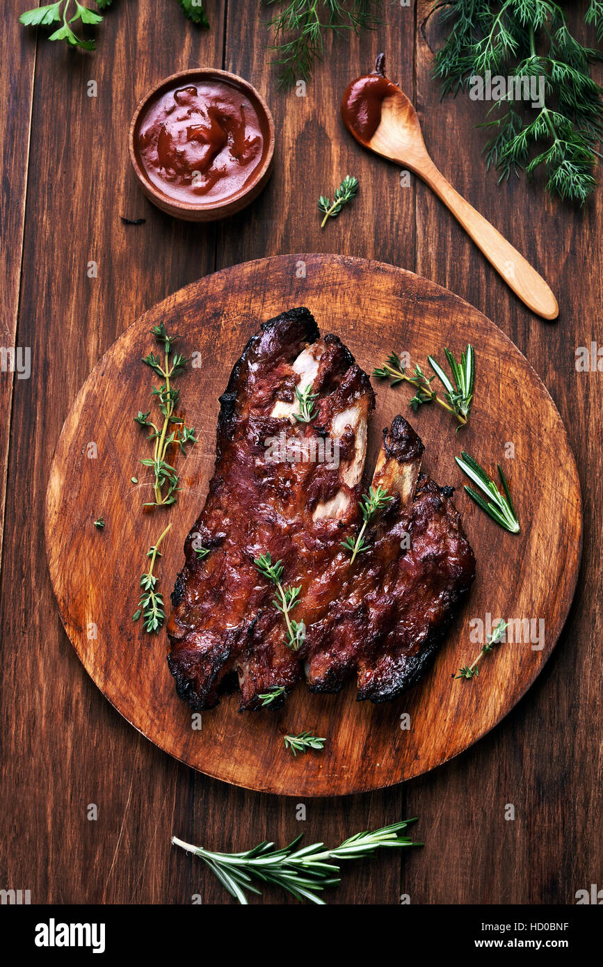 Grigliata di carne di maiale barbecue nervature sulla tavola di legno, vista dall'alto Foto Stock