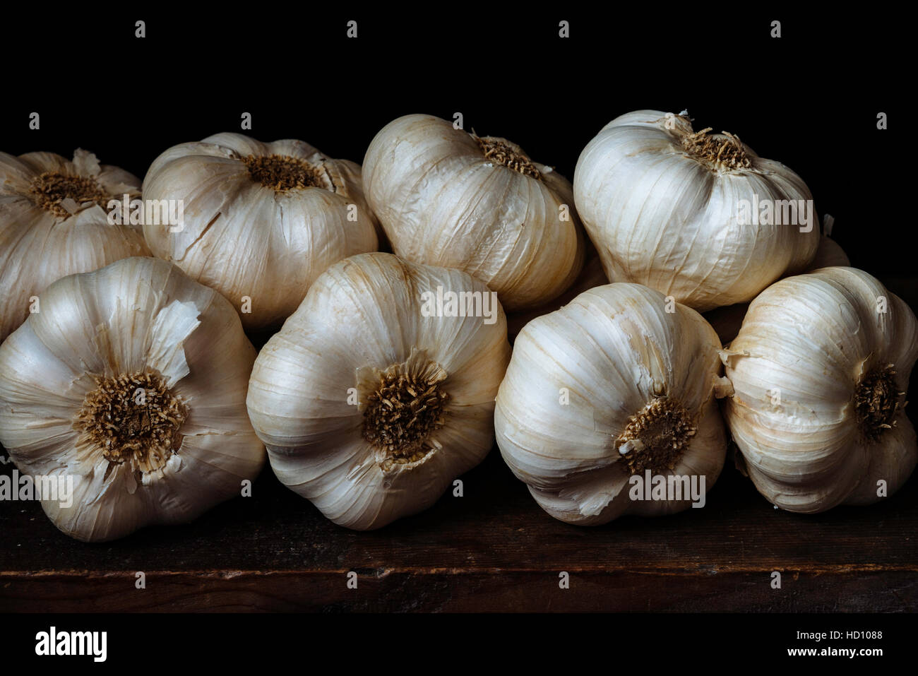 Dettaglio di un mucchio di teste d'aglio contro uno sfondo scuro Foto Stock