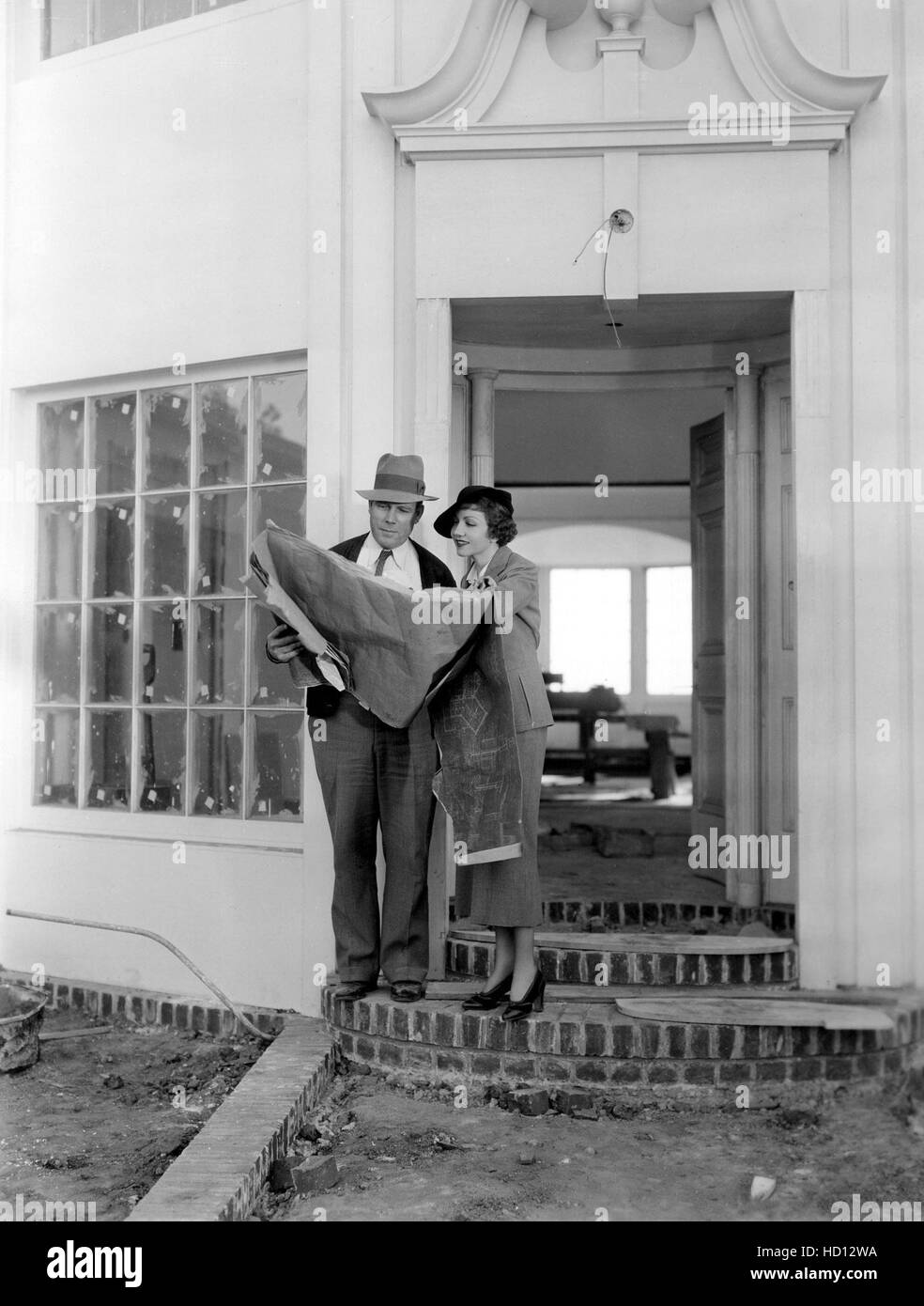 CLAUDETTE COLBERT controlla i piani finali con il suo architetto per la sua Holmby Hills home, 1934 Foto Stock