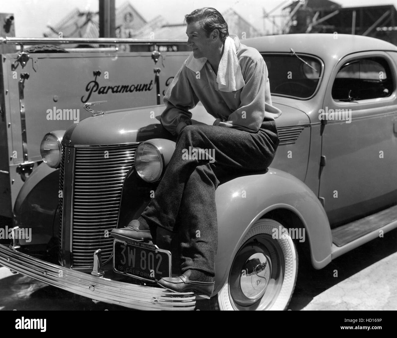 GARY COOPER, seduto sul parafango del suo De Soto, richiede tempo fuori dalle riprese di anime in mare da Paramount molto, 1937. Foto Stock