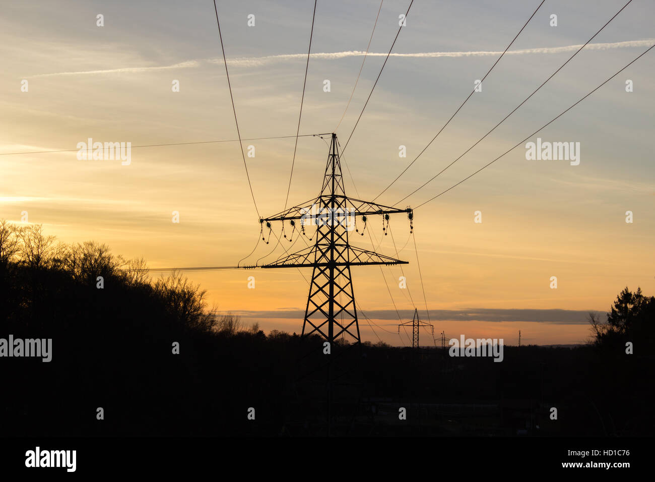 Queste linee elettriche ad alta tensione la fornitura di energia elettrica ad un mondo al tramonto Foto Stock