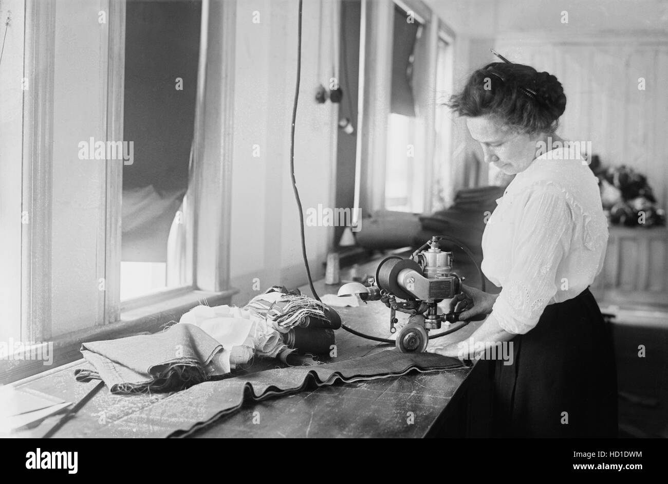 Donna taglio di strisce di bandiera per bandierine americane, Brooklyn Navy Yard di Brooklyn, New York, USA, Bain News Service, Luglio 1917 Foto Stock