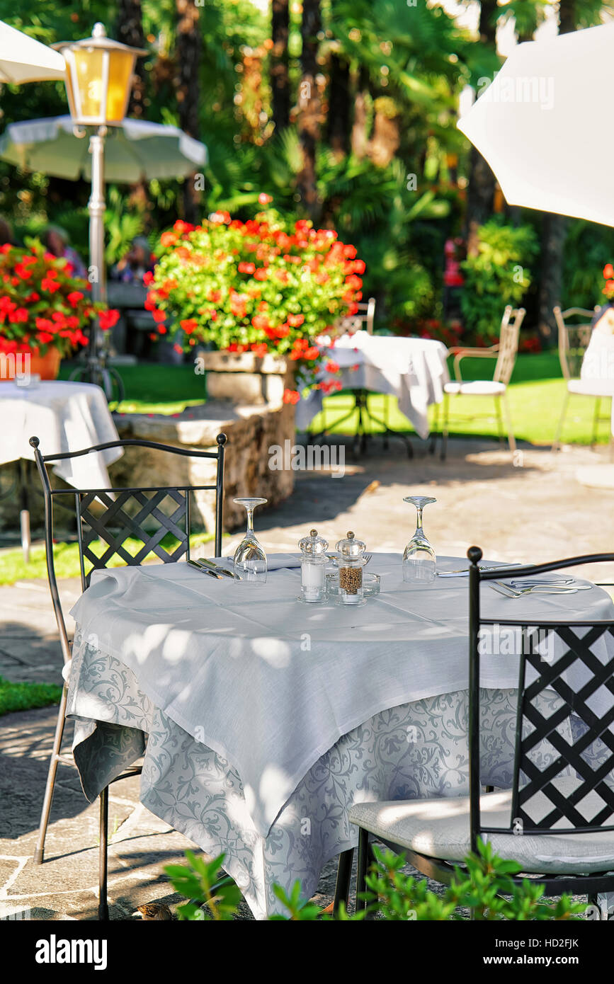 Tipico ristorante terrazza con sedie e tavoli e pronto per un pasto presso il lussuoso resort di Ascona sul Lago Maggiore nel canton Ticino, Svizzera. Foto Stock