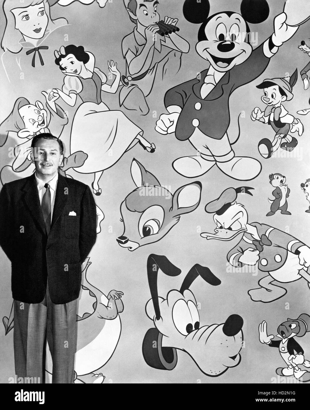 Walt Disney in piedi di fronte ad una galassia dei suoi famosi personaggi  dei cartoni animati, 1950s Foto stock - Alamy