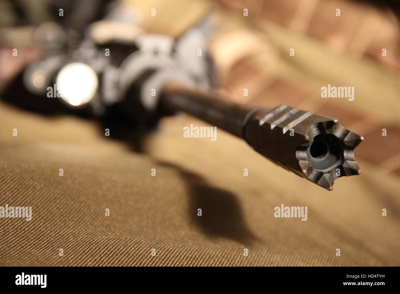 Primo piano del muso e tattica di museruola freno su una personalizzazione AR15 fucile da assalto posa in opera su un imbottito marrone fucile caso Foto Stock