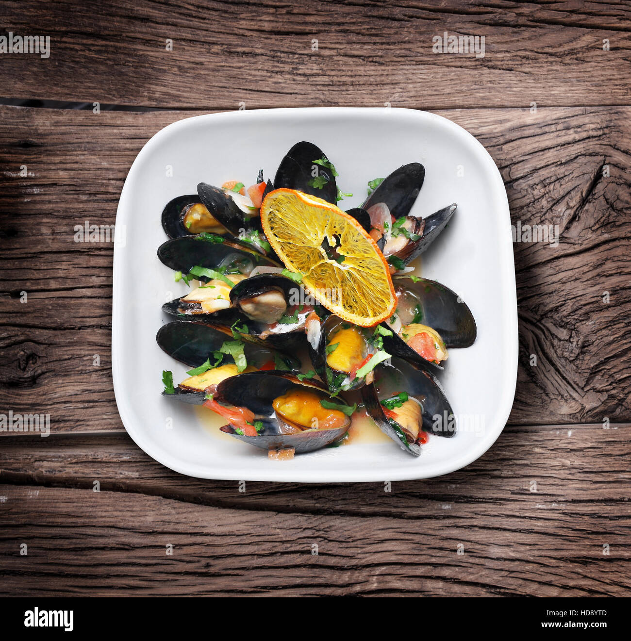 Cozze con erbe verdi e fetta di arancia. Foto Stock