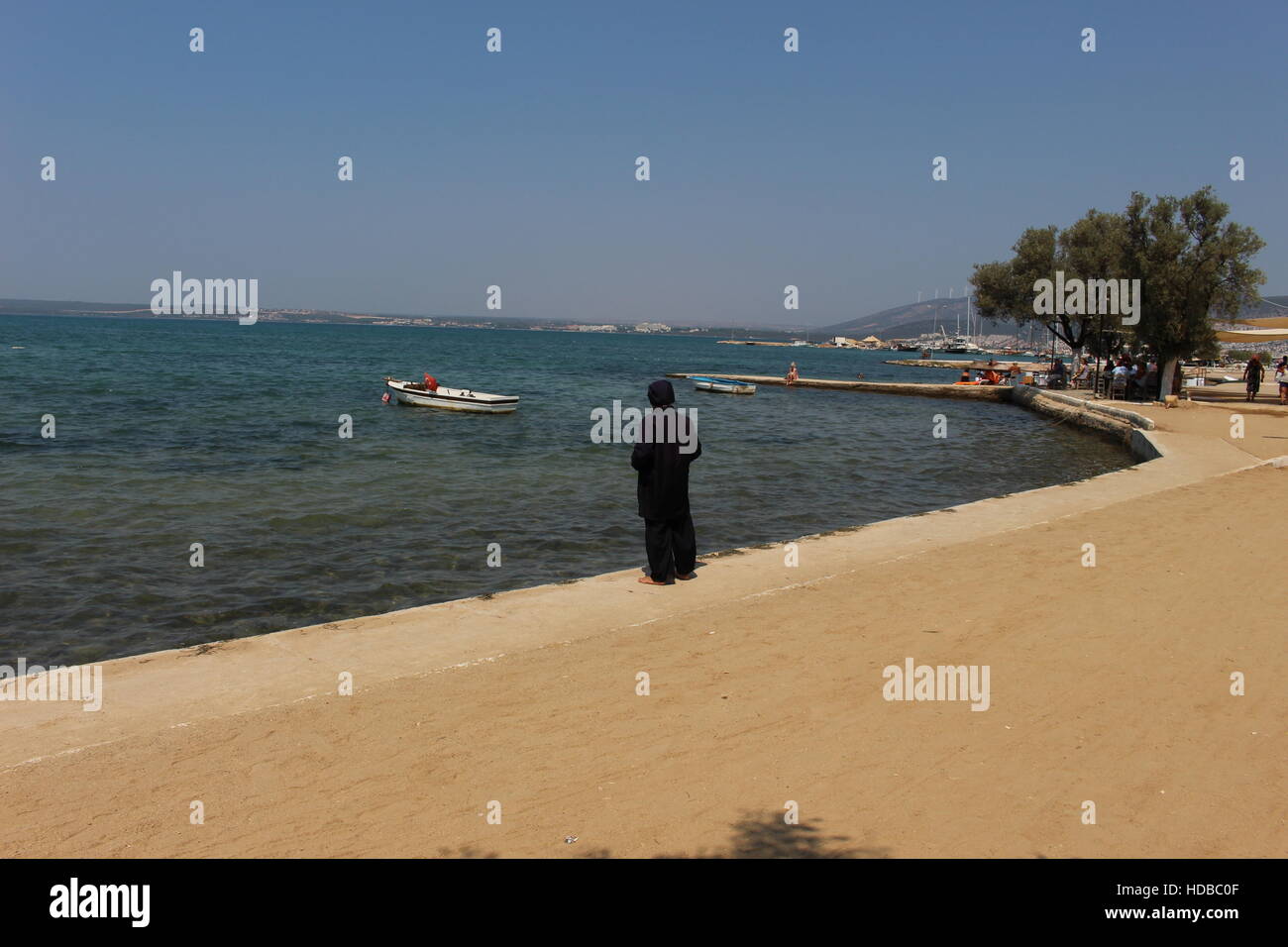 L'islam islamici spiaggia estate usura burkini donna vista baia Akbuk Turchia barca Foto Stock