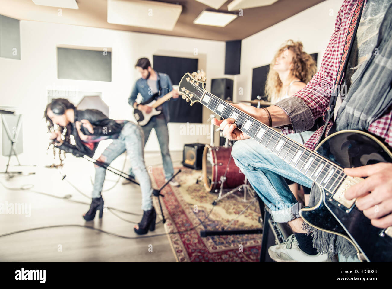 Rock band la registrazione di una traccia musicale in un studio - Amici di eseguire musica in uno studio di registrazione Foto Stock