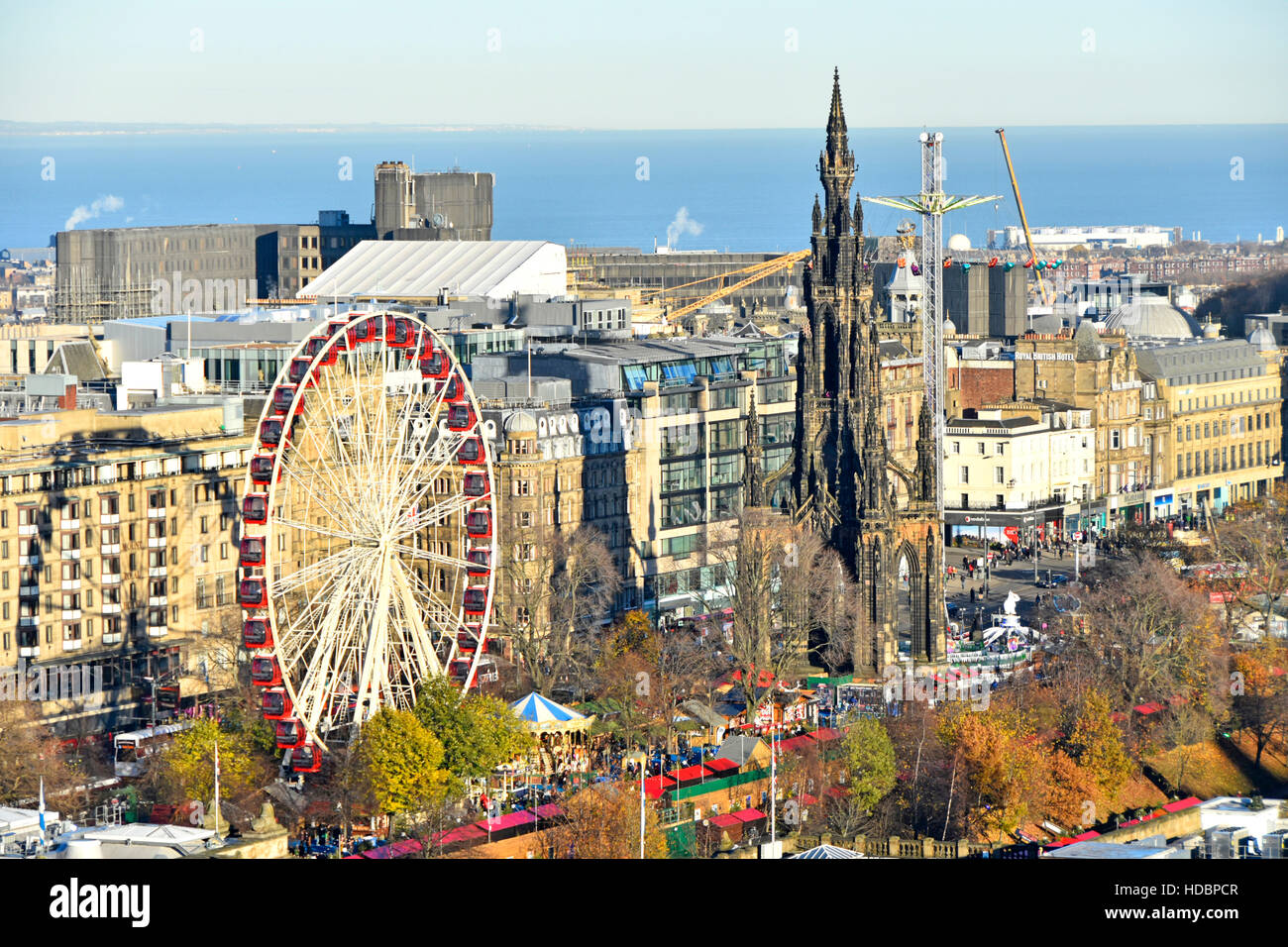 Scozia uk europeo di Edimburgo il Mercato di Natale & Ferris fairground ride a est di Princes Street Gardens Monumento di Scott Scottish Firth of Forth distante Foto Stock