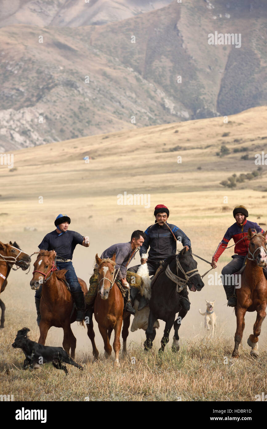 Due uomini a cavallo in lotta per carcassa di capra nel gioco di Kokpar Tudabarai Aksu Zhabagly Kazakistan Foto Stock