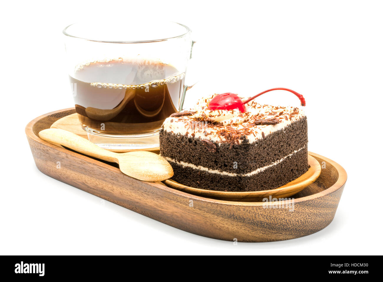 Torta al cioccolato e una tazza di caffè in un vassoio di legno su sfondo bianco Foto Stock