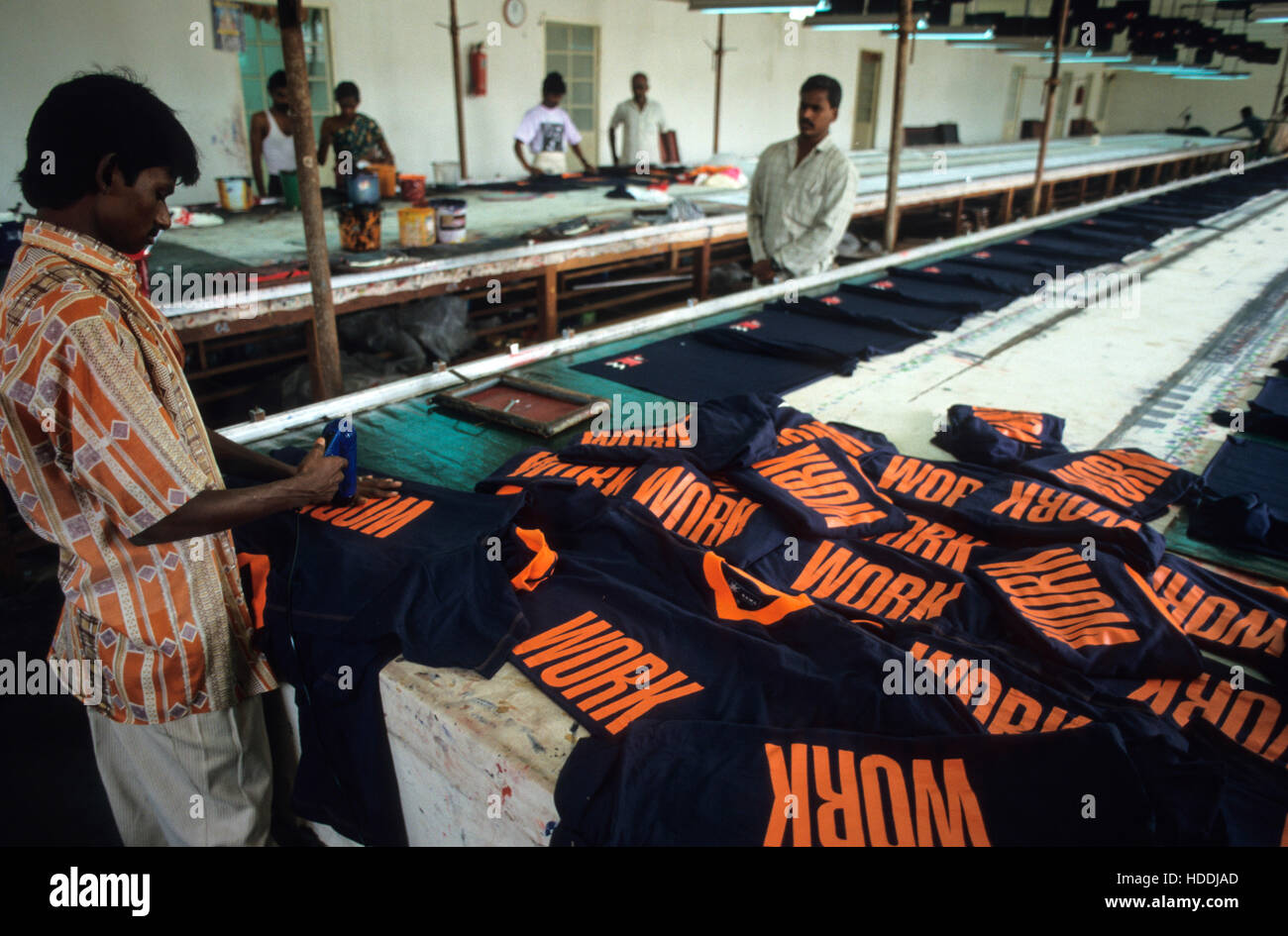 INDIA, nello Stato del Tamil Nadu, Tirupur, fabbrica tessile operaio, stampa T-shirt con la parola lavoro per esportazione - abbigliamento gli ornamenti T-shirt cloting stampa stampare per la scrittura di lettere Foto Stock