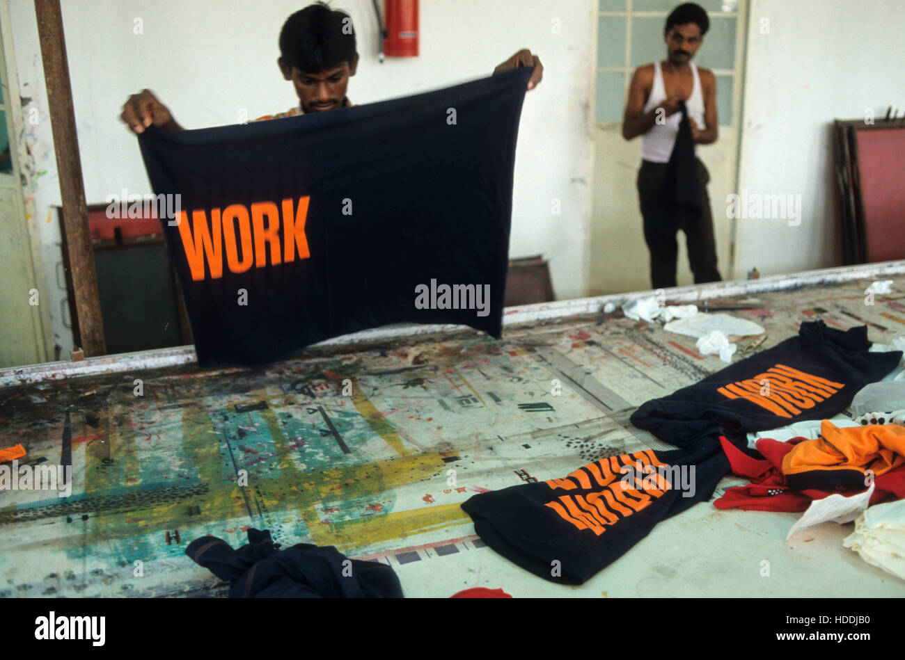 INDIA, nello Stato del Tamil Nadu, Tirupur, fabbrica tessile operaio, stampa T-shirt con la parola lavoro per esportazione - abbigliamento gli ornamenti T-shirt cloting stampa stampare per la scrittura di lettere Foto Stock