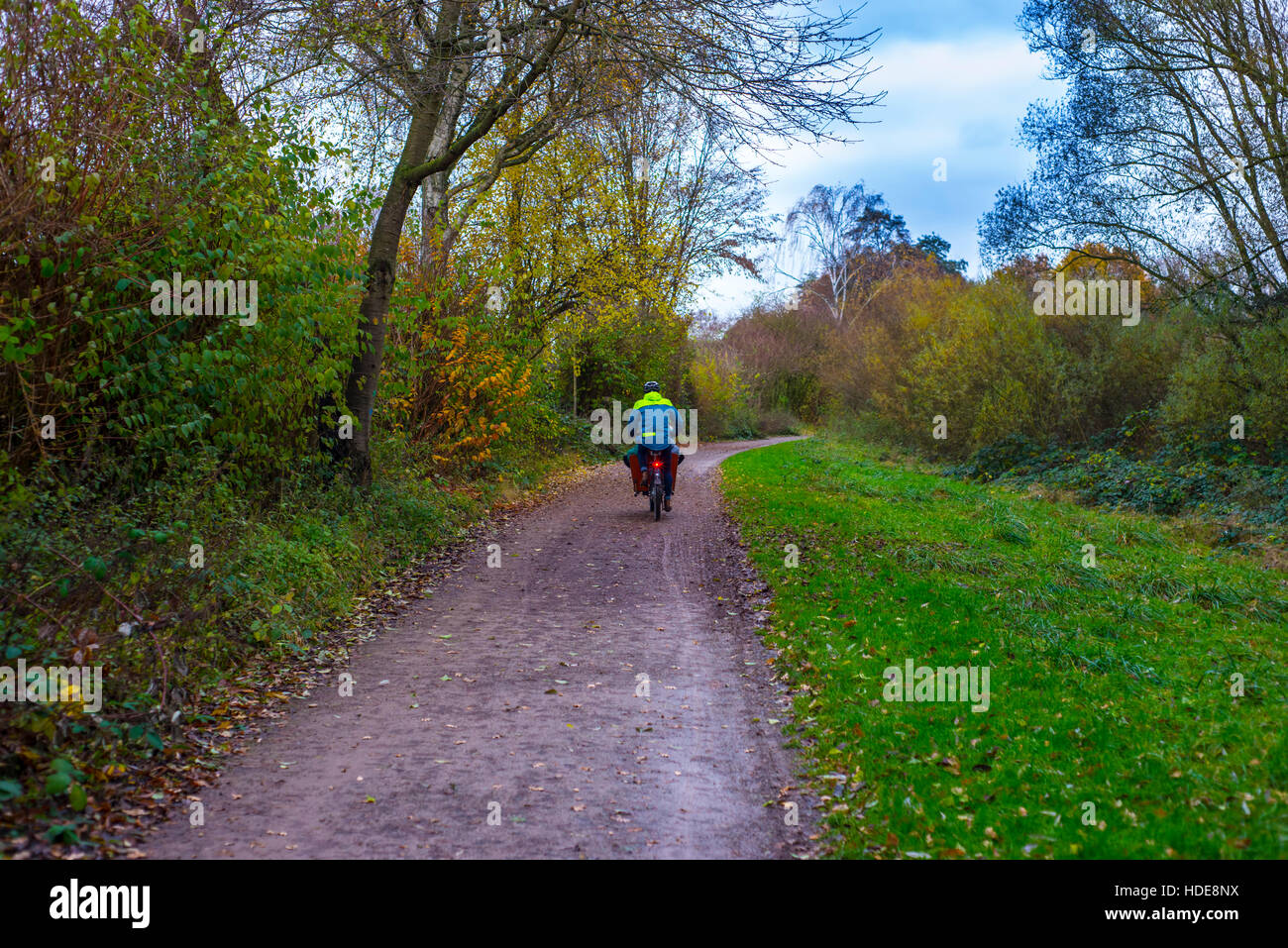 Uomo in bicicletta attraverso la foresta con un cestello il trasporto dei bambini a scuola Foto Stock