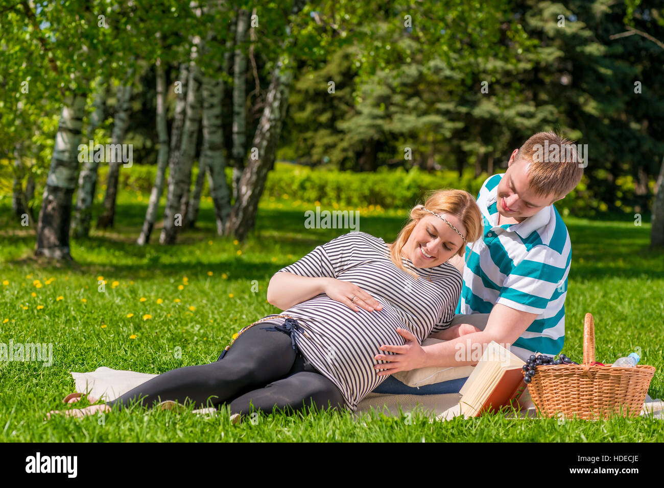Una donna e un uomo di trascorrere il loro tempo libero al picnic, la donna è in stato di gravidanza Foto Stock