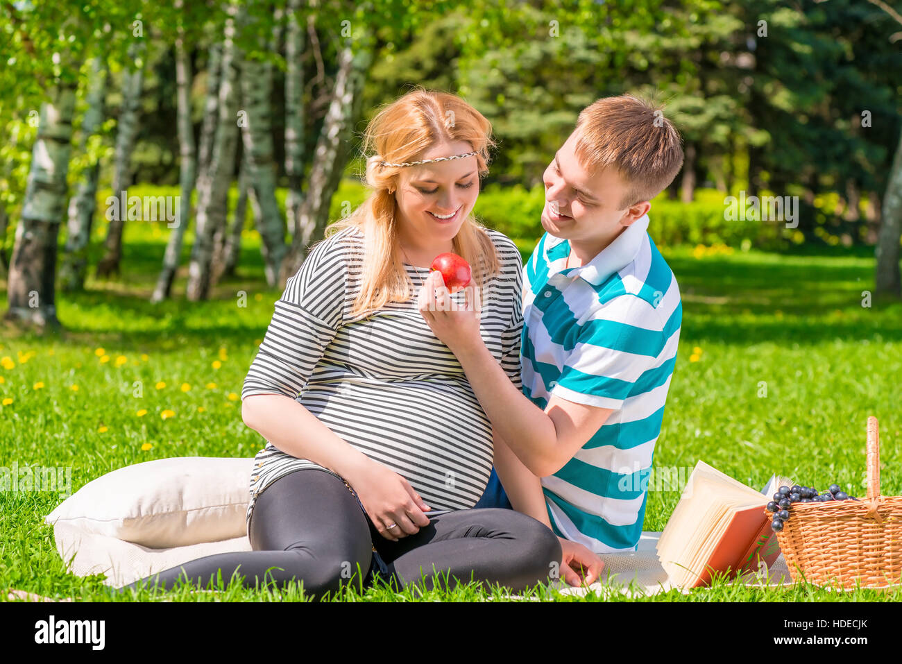 Ritratto di una felice coppia incinta ad un picnic con Apple Foto Stock