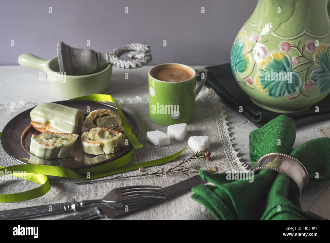 Eclair con decorazioni in verde sul tavolo orizzontale Foto Stock