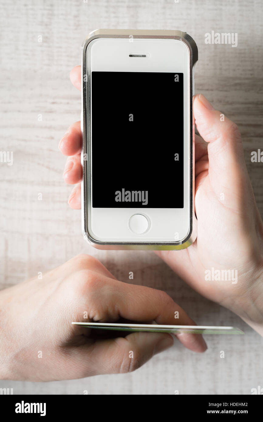 Le mani con carta di credito e il telefono mobile in verticale Foto Stock