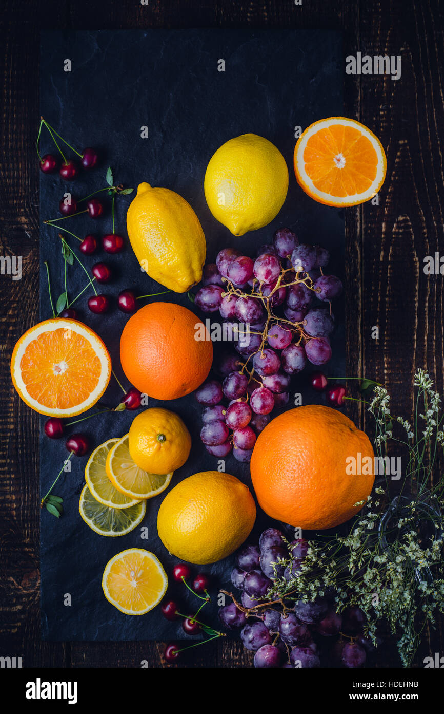 Un assortimento di frutta su sfondo scuro in verticale Foto Stock