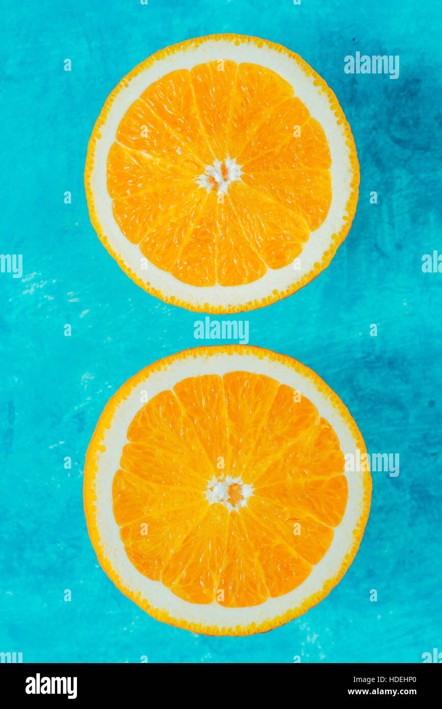 Metà di colore arancione su sfondo ciano vista superiore Foto Stock