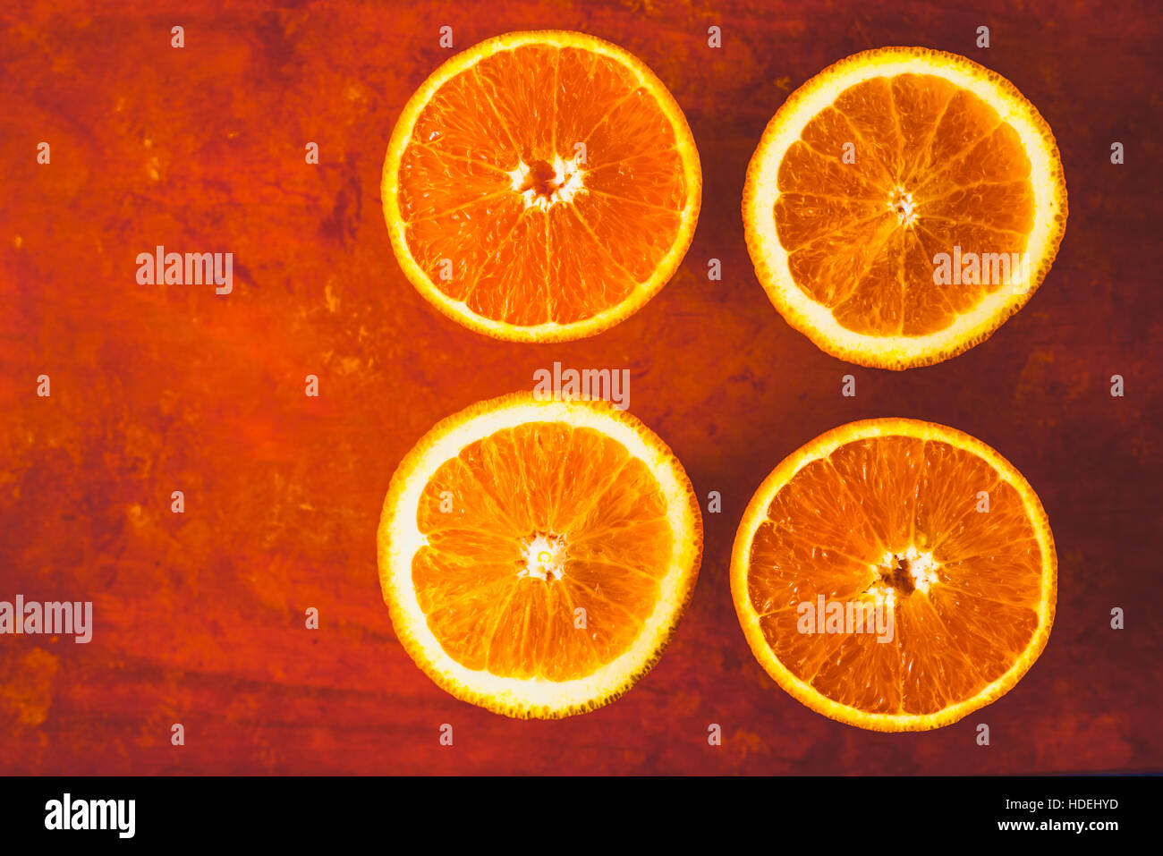 Fettine di arancia sullo sfondo di terracotta vista superiore Foto Stock